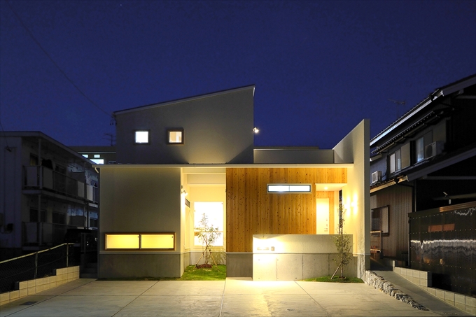 シンプルな白い壁と温かみのある木の質感が浮かび上がる夜景
