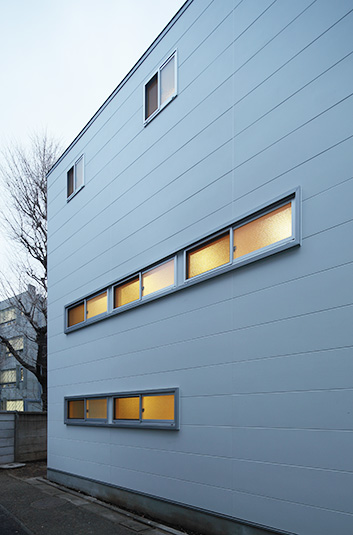 長窓からの灯りが白い外観に彩りを添える