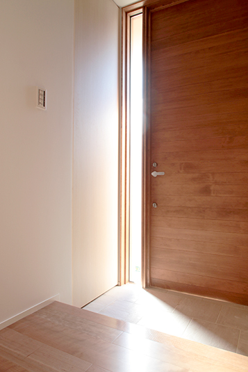 光の差し込む細窓がある玄関