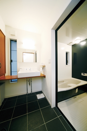 広い開口部のあるモノトーンでシャープなバスルーム