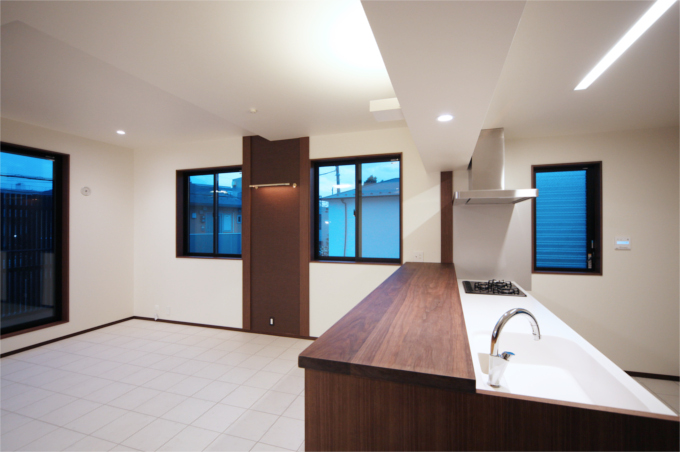 白いキッチンに木目のカウンターがアクセントに