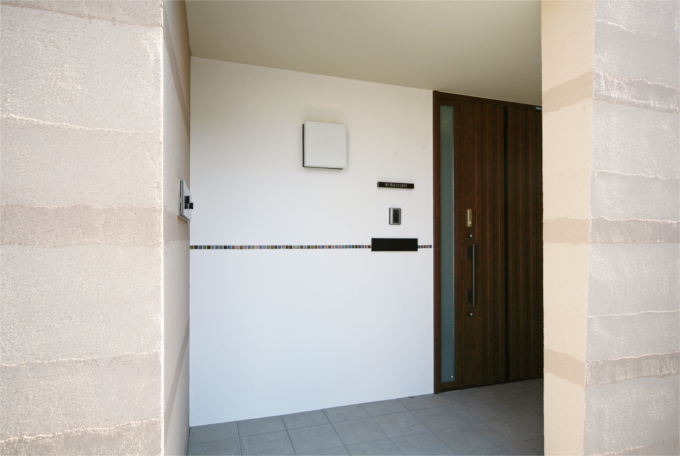 白い壁にタイルがデザインされたモダンな玄関