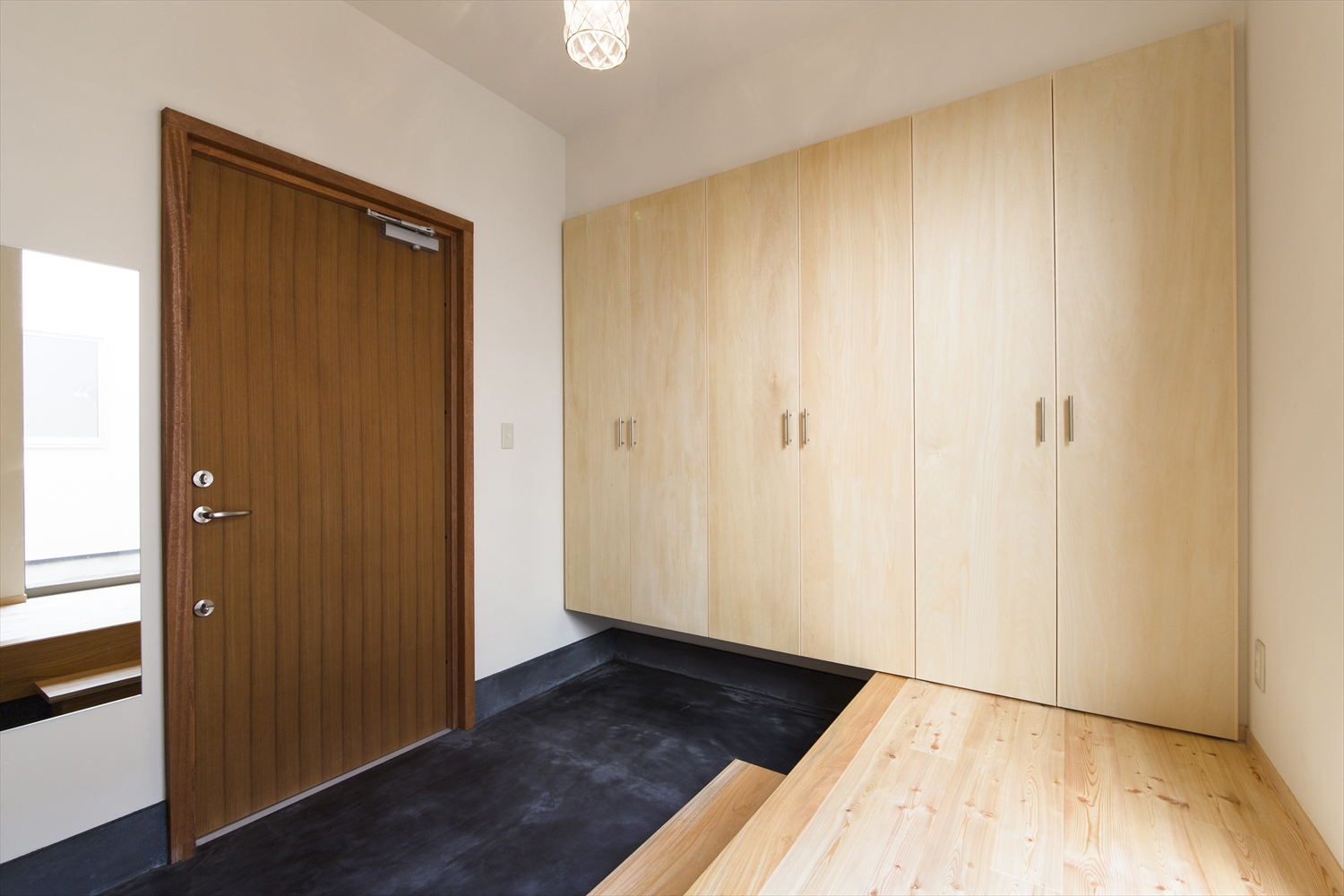 墨色の玄関土間と木製玄関扉