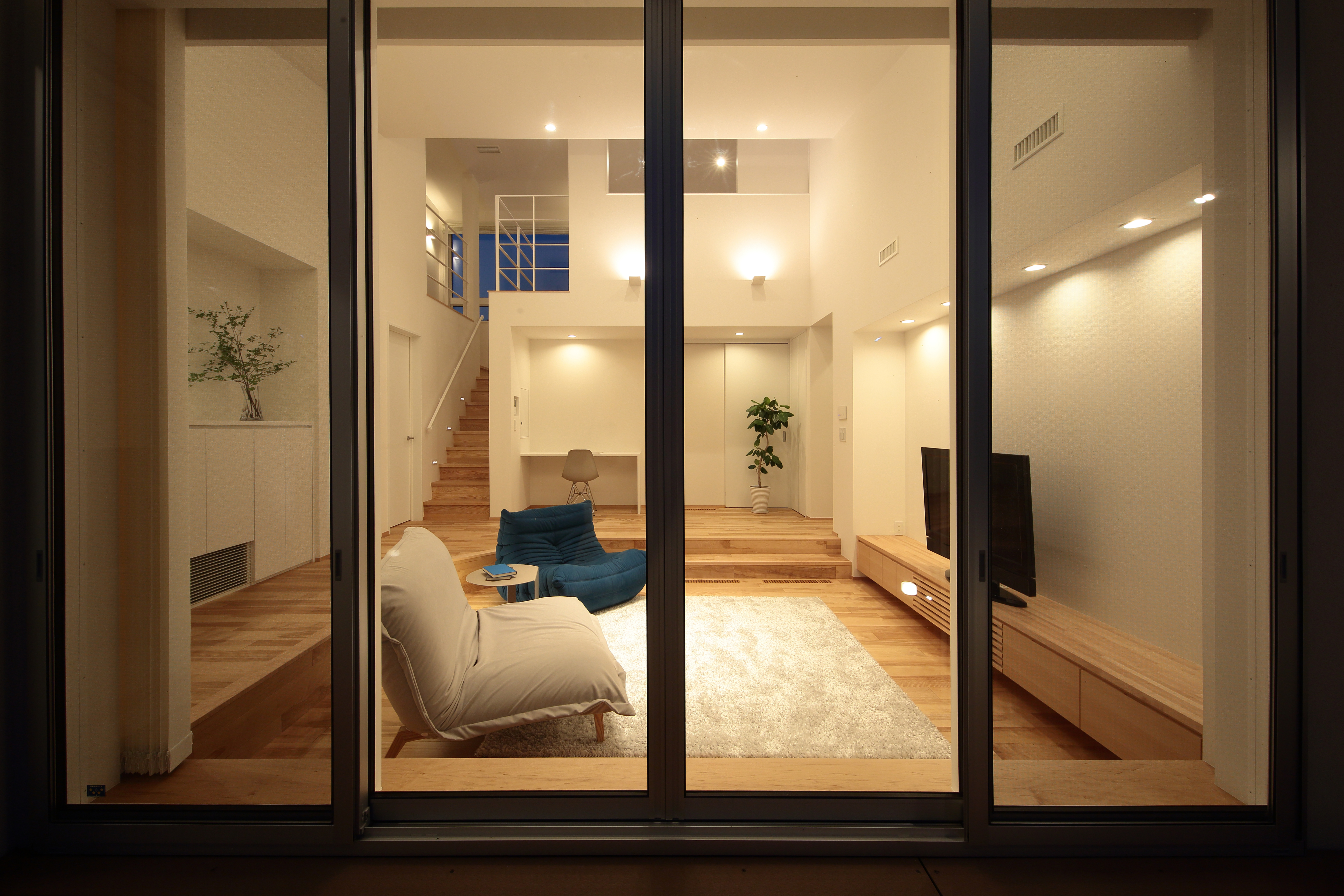 ダウンフロアリビングを映す窓の家