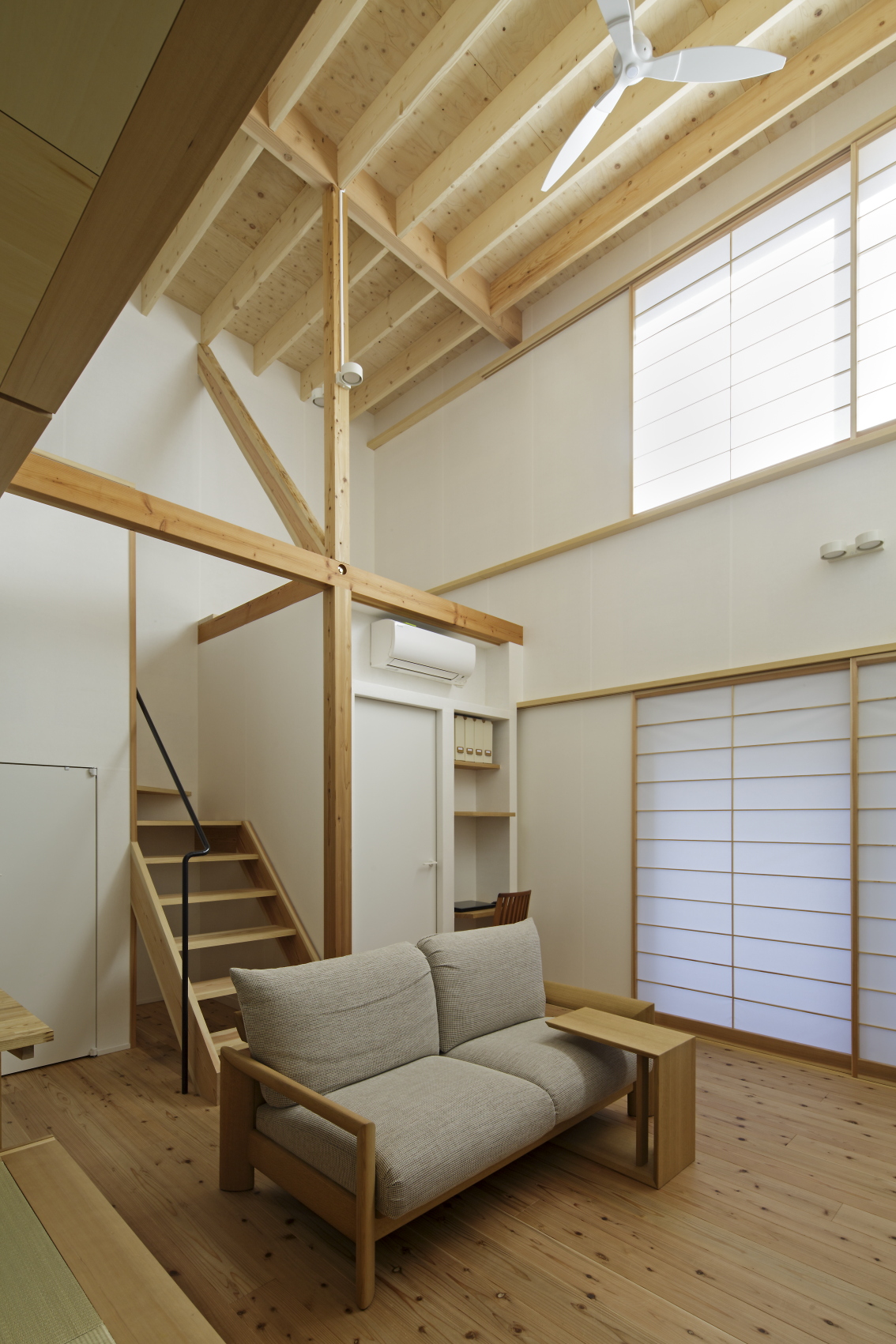 柱・梁・階段などの木の質感が印象的な天井の高い部屋