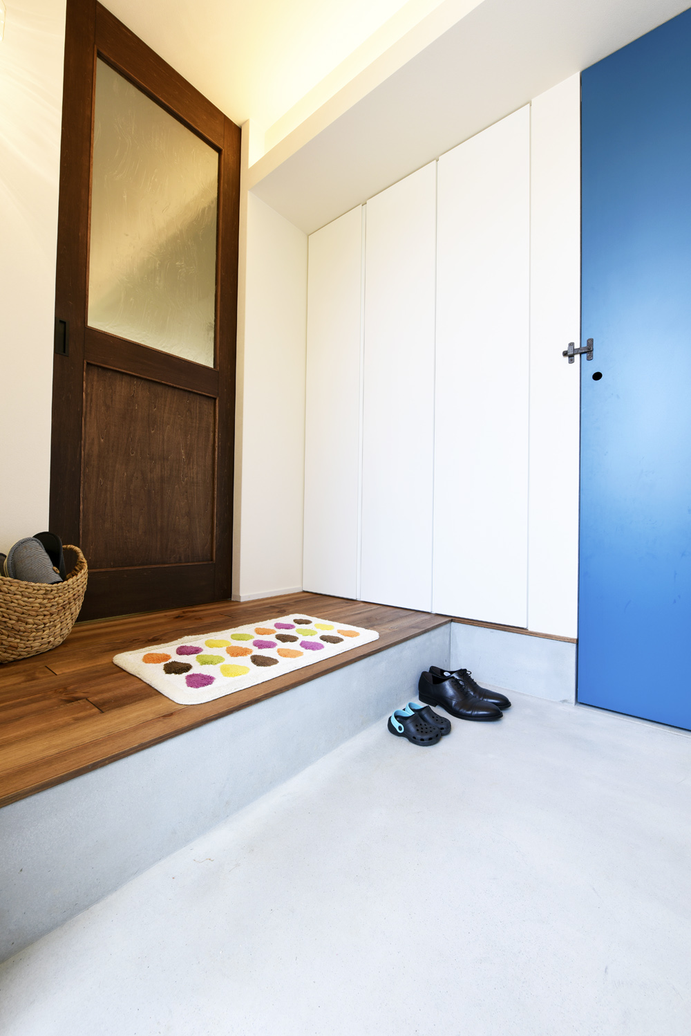 ブルーのアクセントが映えるコンパクトな玄関土間