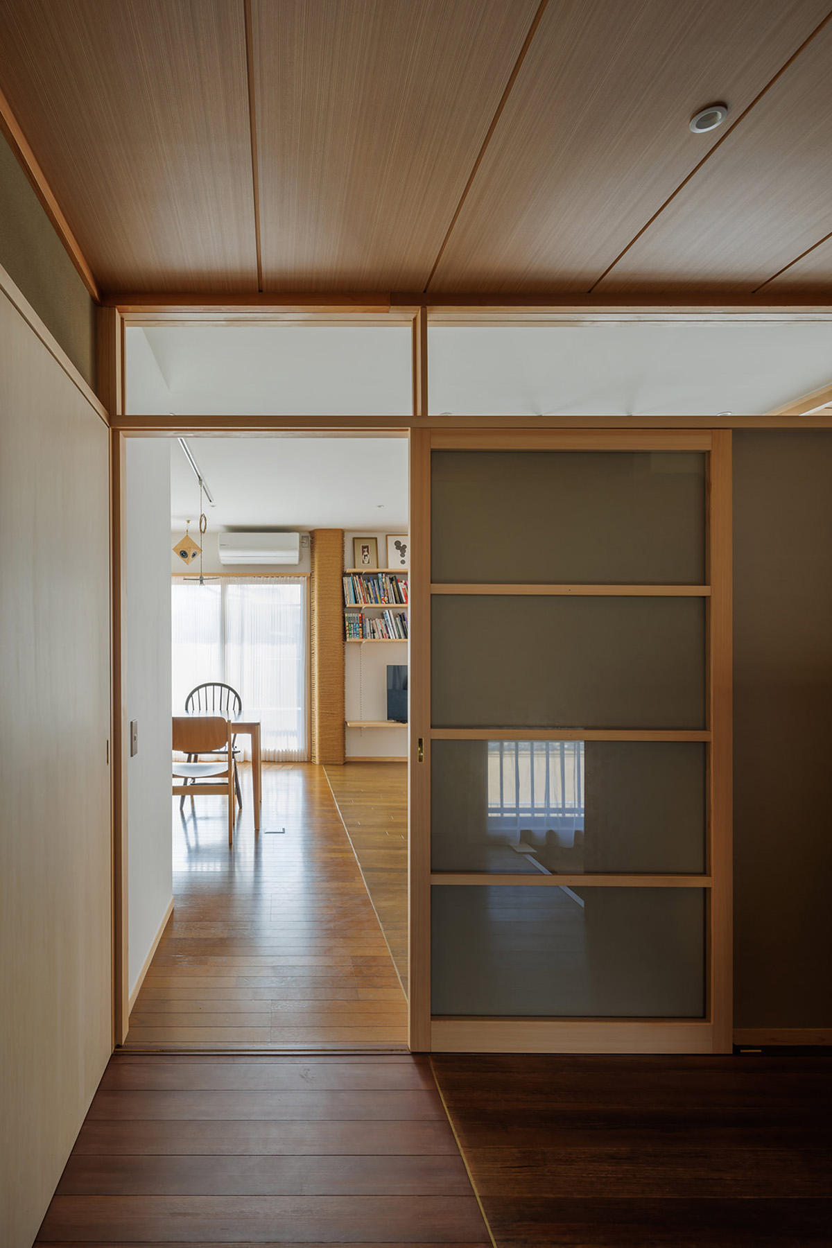 廊下より見る。フローリングのパッチワーク。左奥：既存、右奥：新設、手前左：新設、手前右：既存。奥はオーク、手前はラオス松のフローリング。