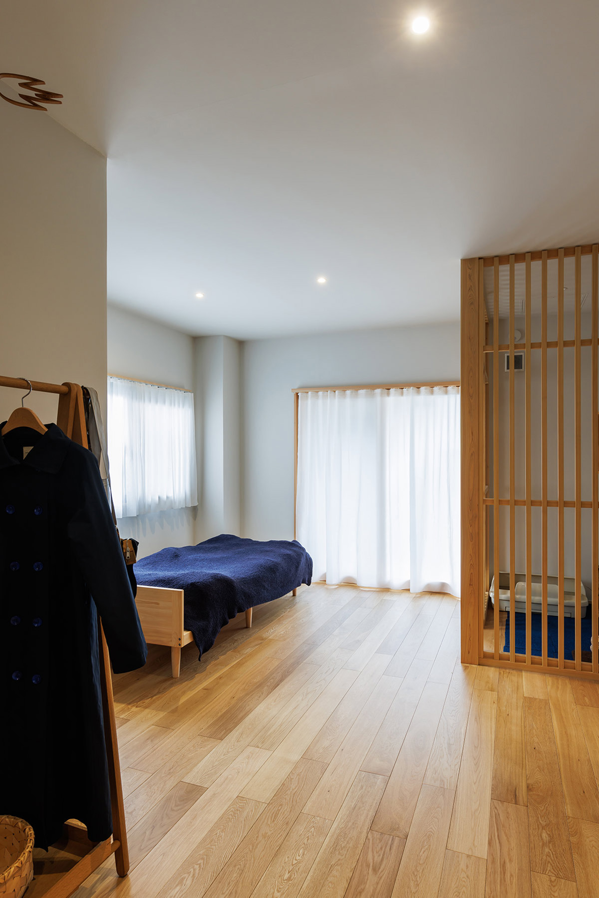 床はオーク無垢フローリング。壁・天井はペイント。既存アルミサッシの内側に製作木製建具とカーテンを入れて柔らかい印象に。