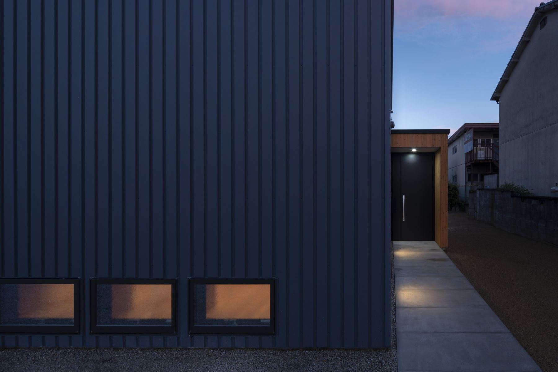 長めのアプローチで通りと居間の心理的な距離を離す。