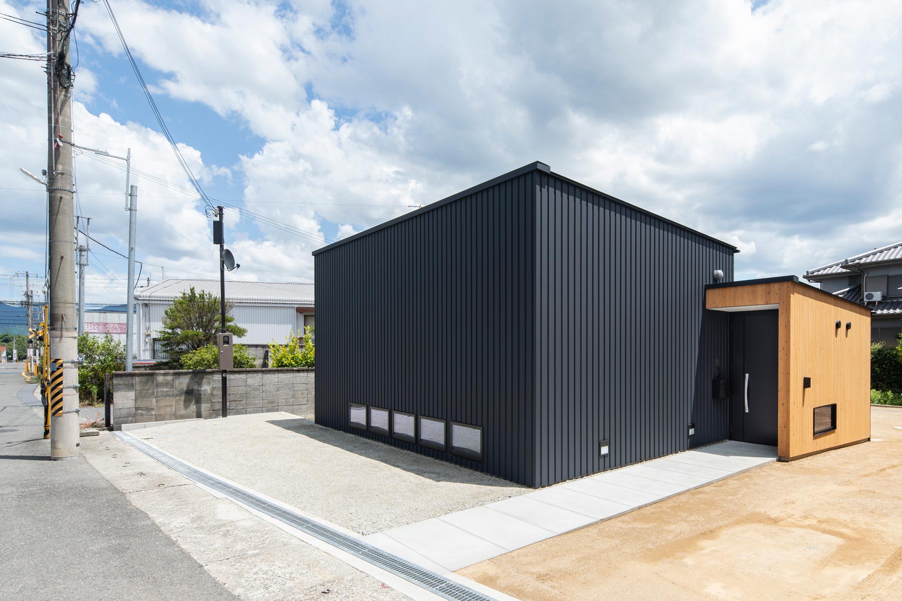 北西から見る。道路より約30cm下がった敷地を利用して、道路から室内へ最小段差でアプローチ。