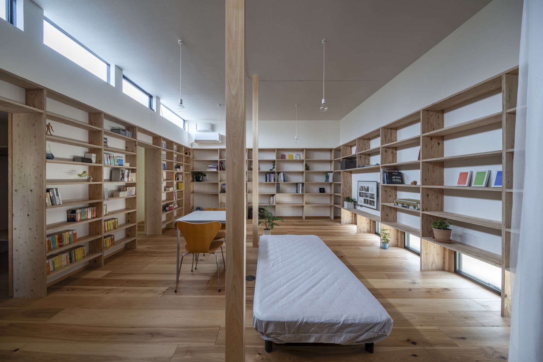 ひとり暮らしの食・寝・働・憩を集約した大きな居間。