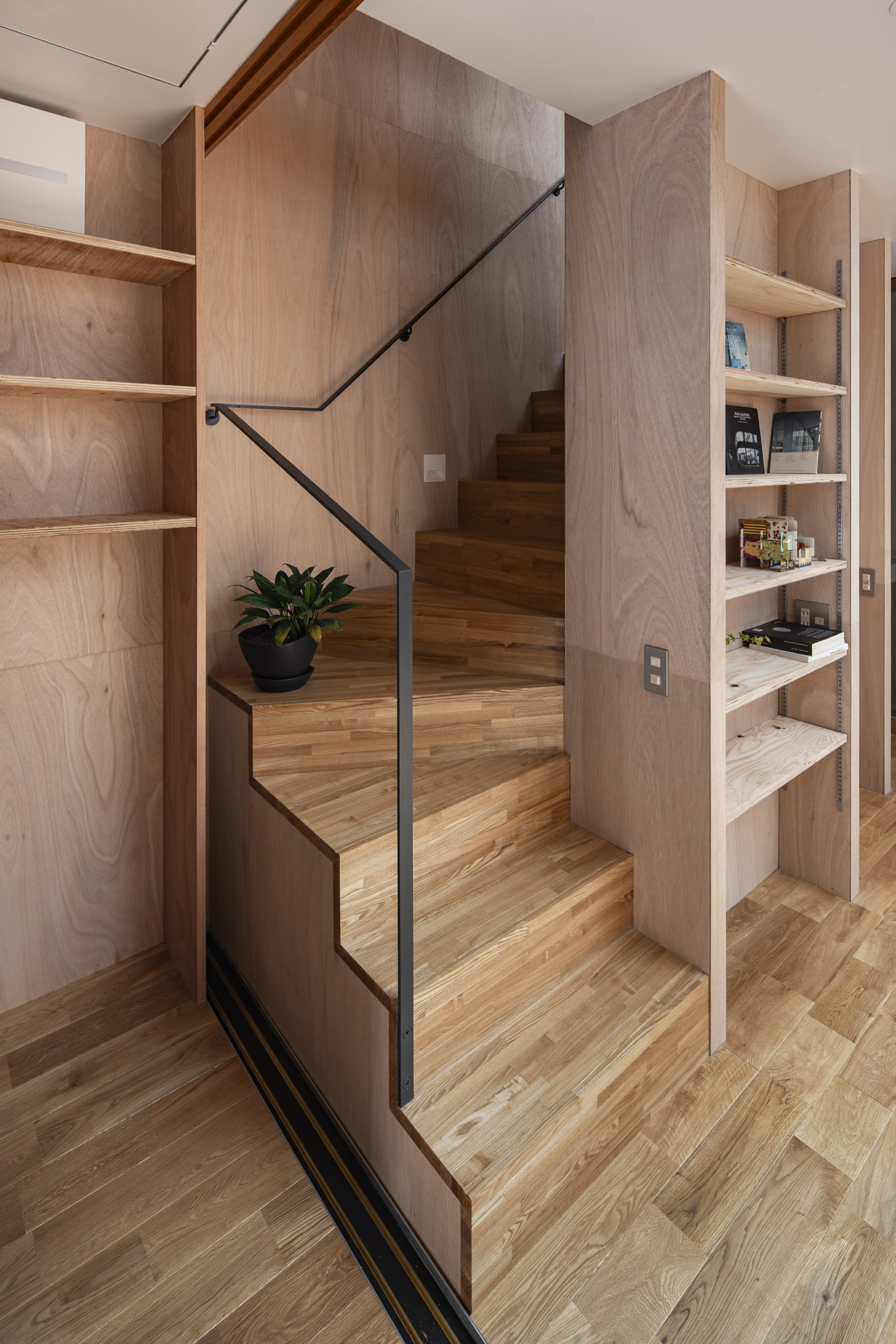 コンパクトな回り階段。手摺は細身のスチールフラットバー。