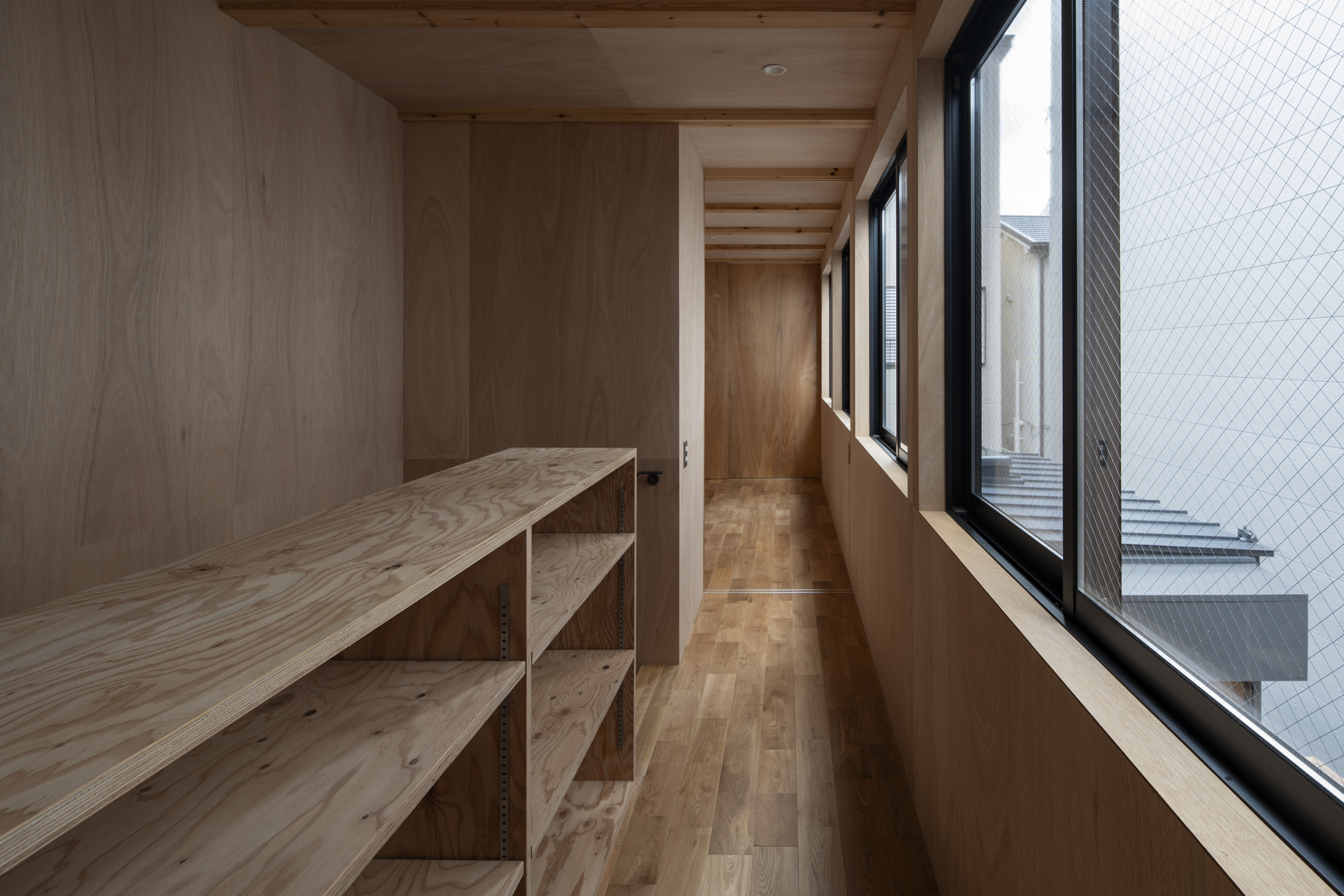 2階は息子さんの部屋とゲストルーム、収納を最小限の容積に納める。広縁・居間に面した連続窓から光が入る。