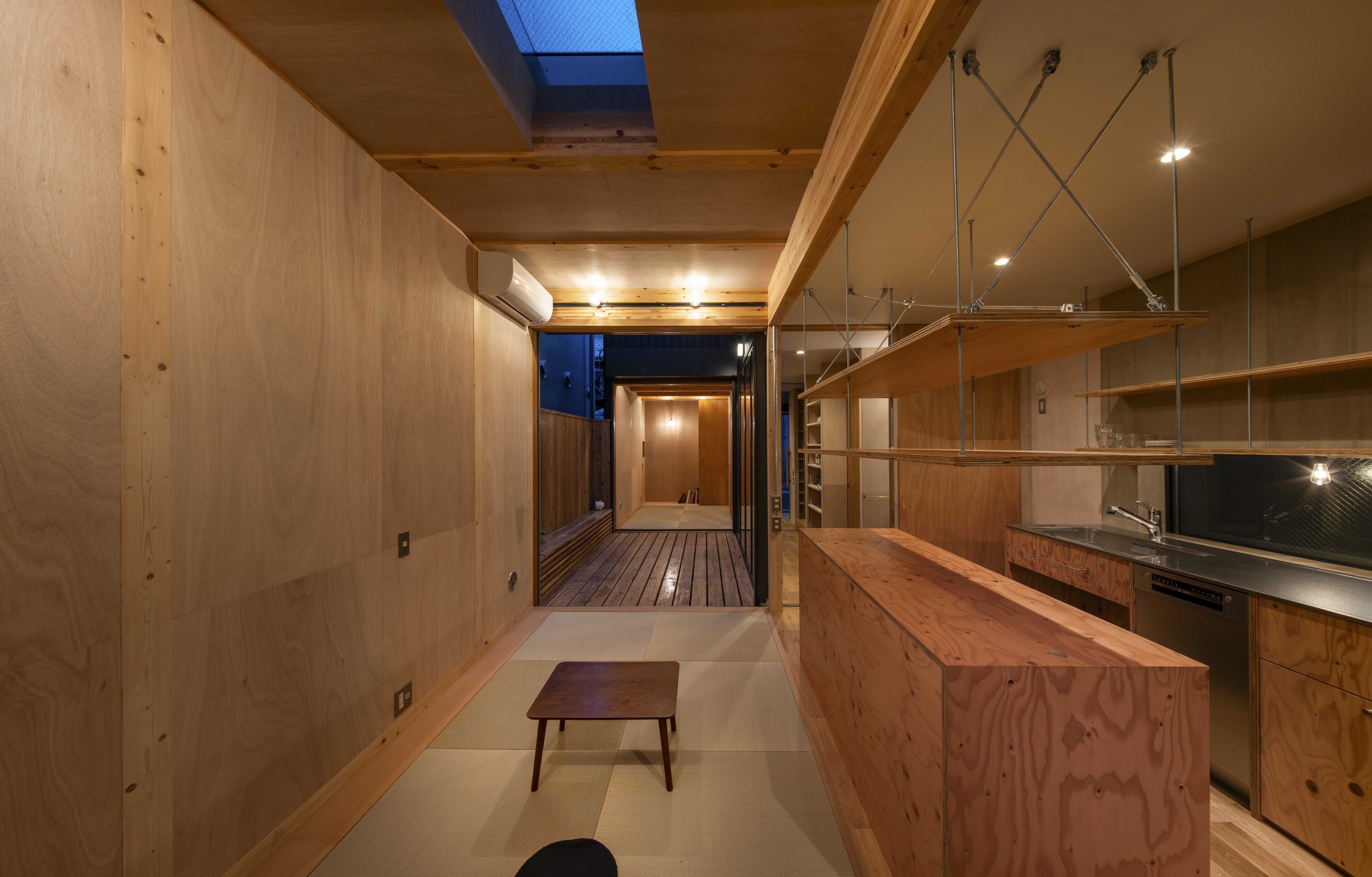 キッチンは幅2,700。シンプルながらアイランドと釣戸棚、食洗機を備え実用性重視。シンク下はオープンにしてゴミ箱を設置。奥に出窓を設けてワークスペースを拡張。