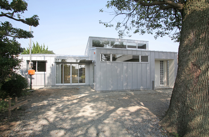 大きなクスノキの横から見た外観