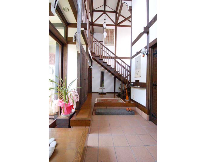 玄関から見た吹き抜けのある階段と中庭出入口