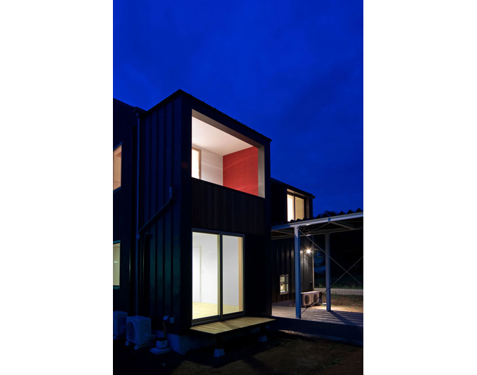 壁の一面を赤系にペイントしたバルコニー