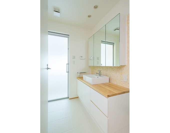 洗面室。浴室のサッシからの日差しが明るい。