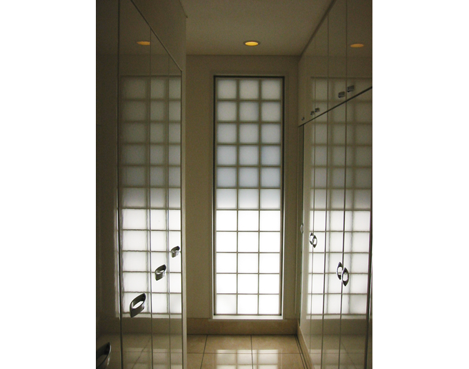 ガラスブロック越しの柔らかな光が入る玄関収納