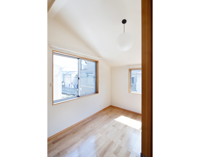 傾斜天井に2面に窓のある寝室