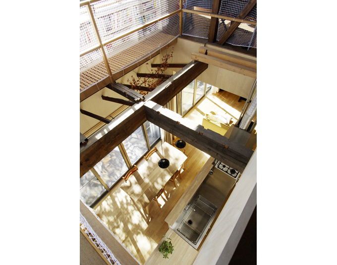 吹抜けから1階キッチンダイニングを見る