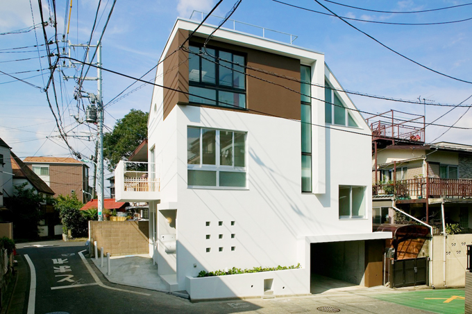 緩やかな斜面に馴染ませて建つスキップフロアの家