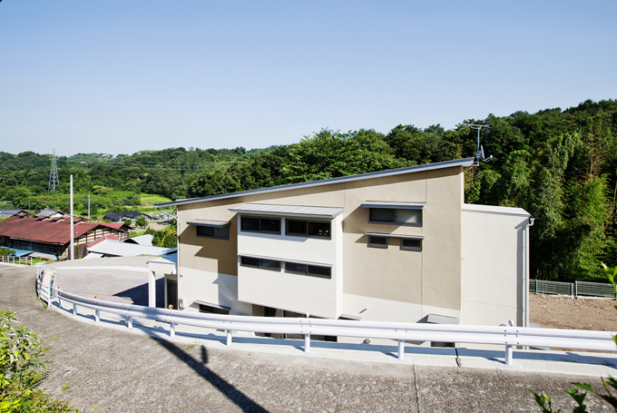 道路の勾配に屋根や窓を合わせた外観