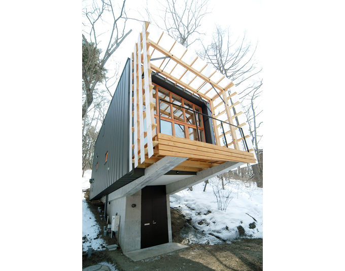地階の玄関アプローチから上部の建物を見上げる