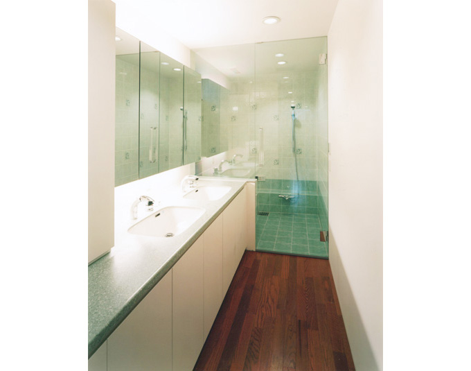 洗面所と連なる透明感のある浴室