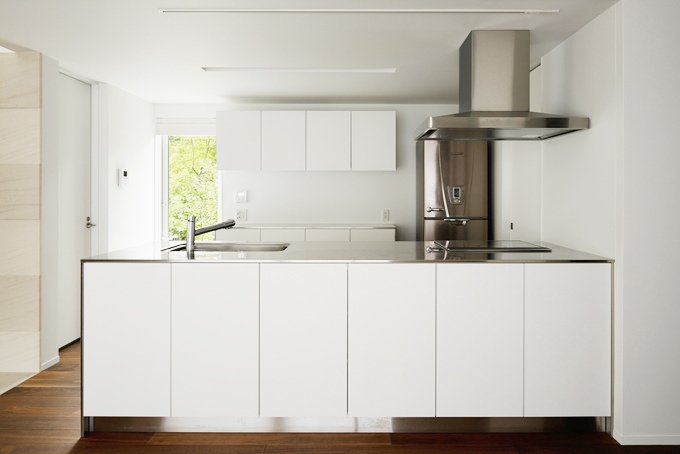 キッチン。ステンレスカウンターと白い扉でシンプルモダン