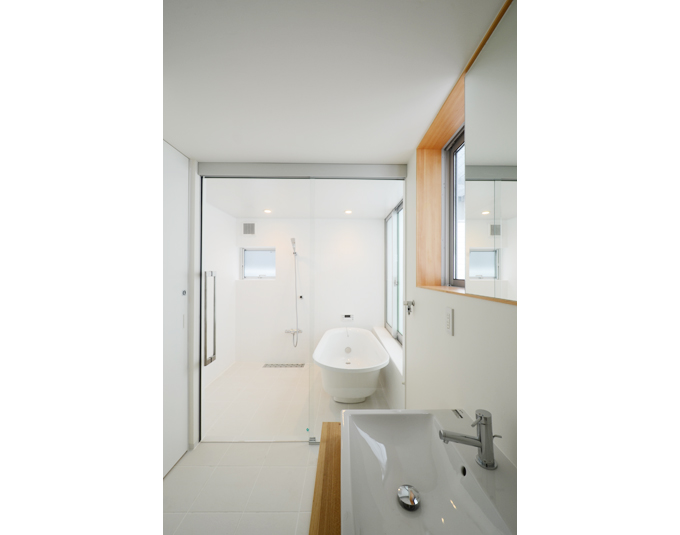 ガラス戸で広々空間 バスルームと洗面スペース