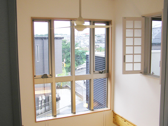 大きな窓から自然光が降り注ぐ洋間の吹抜け