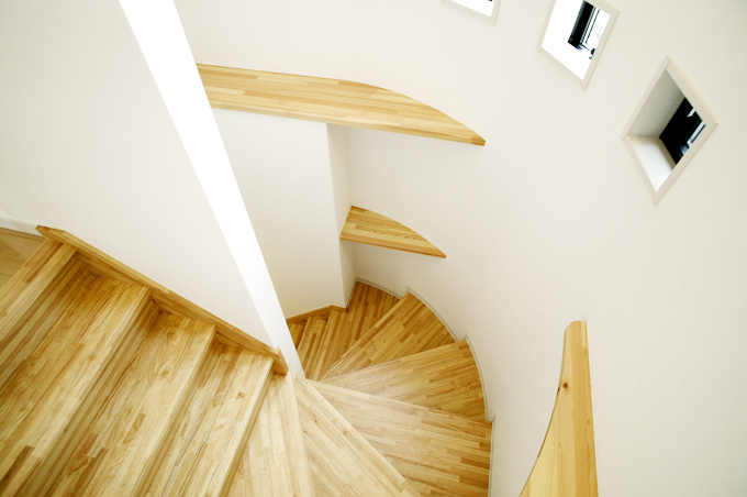 R状の形を活かして収納棚を付けた階段