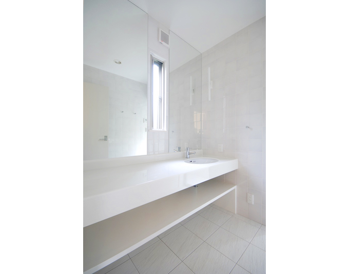 光沢のある白でまとめた洗面室