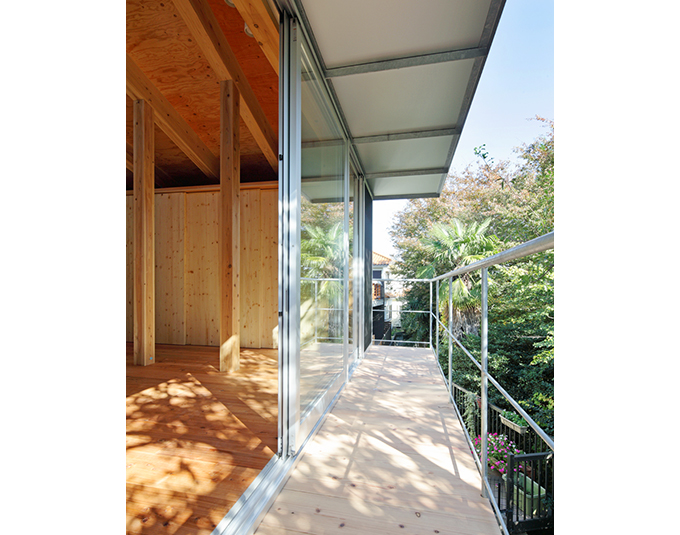 木漏れ日の注ぐ庇に覆われた木製のバルコニー