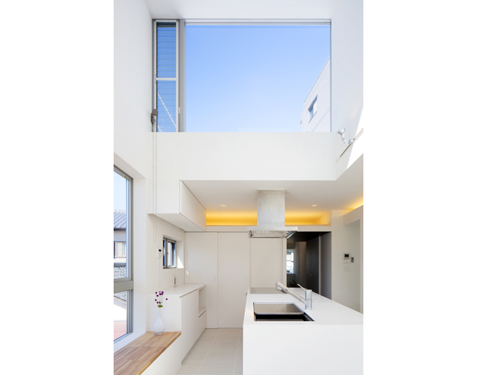 ハイサイドの窓に青空が広がる吹き抜けキッチン