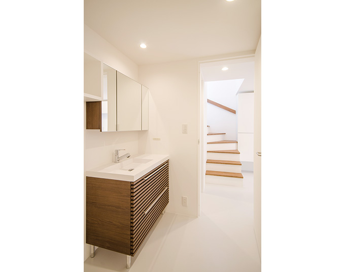 白い壁と調和した木目の洗面
