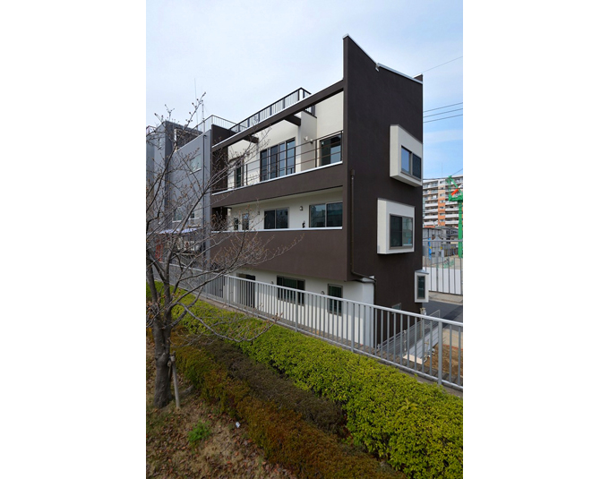 桜並木から臨む三階建住宅