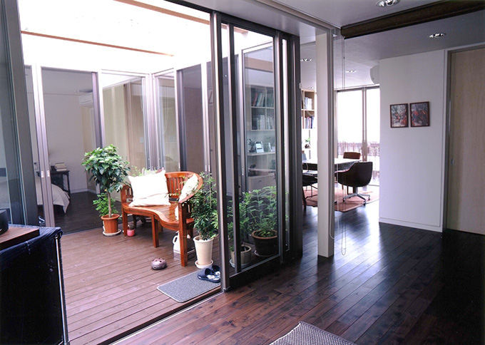 室内の床と段差無しで連続する、中庭を囲むワンルーム