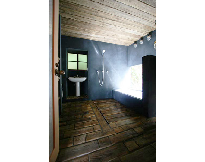 床、天井に杉の古材を再利用。壁は墨モルタル仕上げ。玄関から直接アプローチできる。