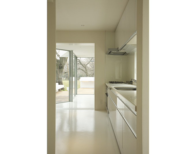 全面ガラスからの光に溢れる白いキッチン