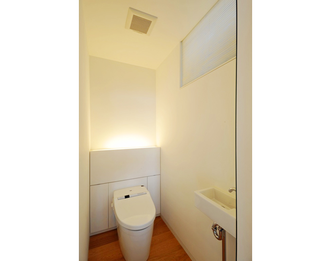 タンクレストイレの背面には扉付の収納を配置